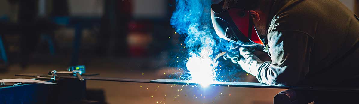 Industrial welder with torch and protective helmet