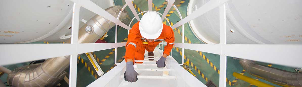 Process engineer climbing up to the top of gas dehydration vessel to inspect oil and gas central processing platform