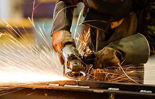 Electric wheel grinding on steel structure in factory