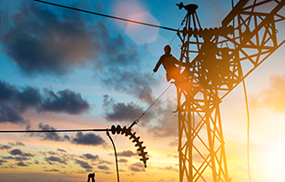 Electrician working on electrical tower and power lines